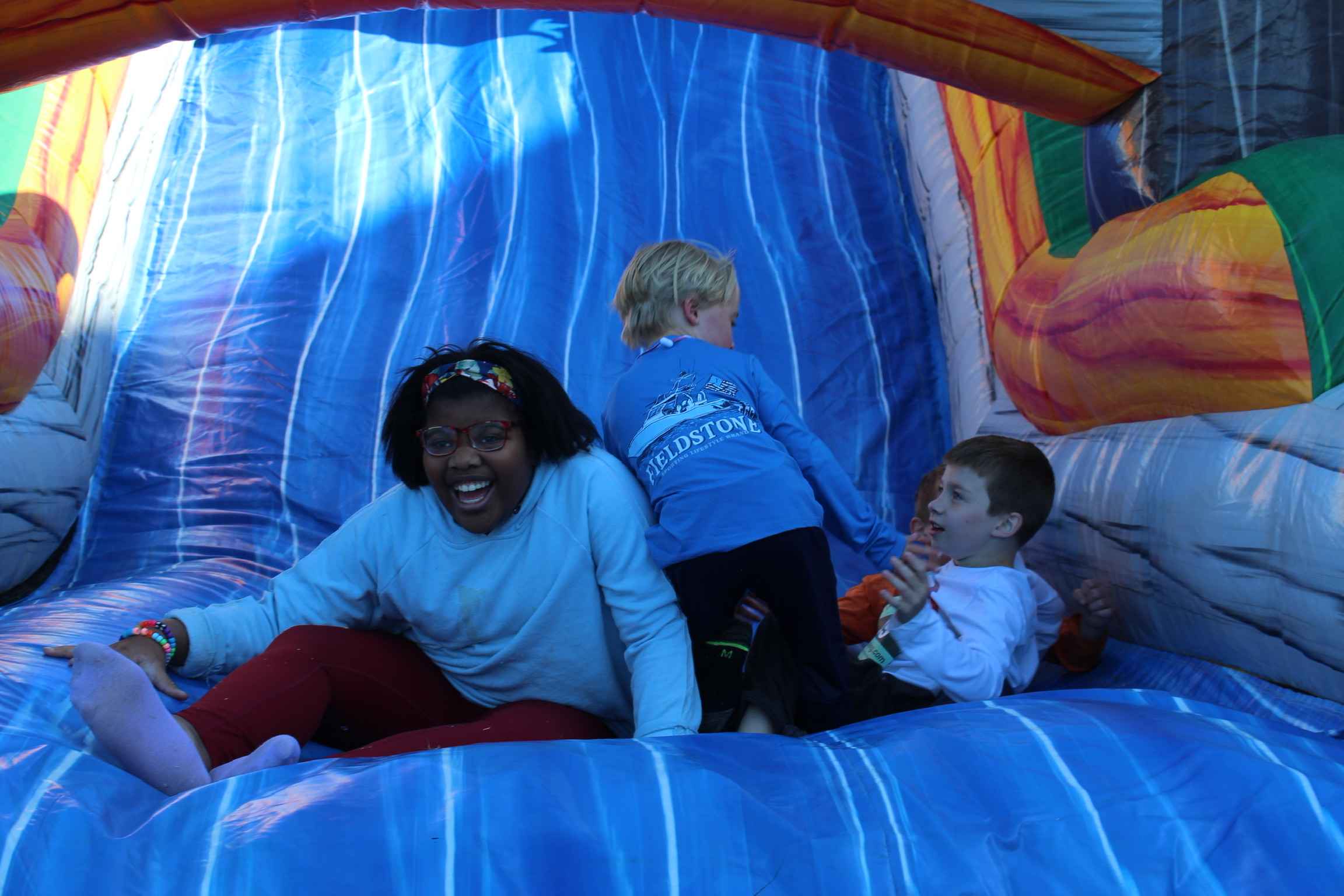Three children enjoying playing in the Bounce House.